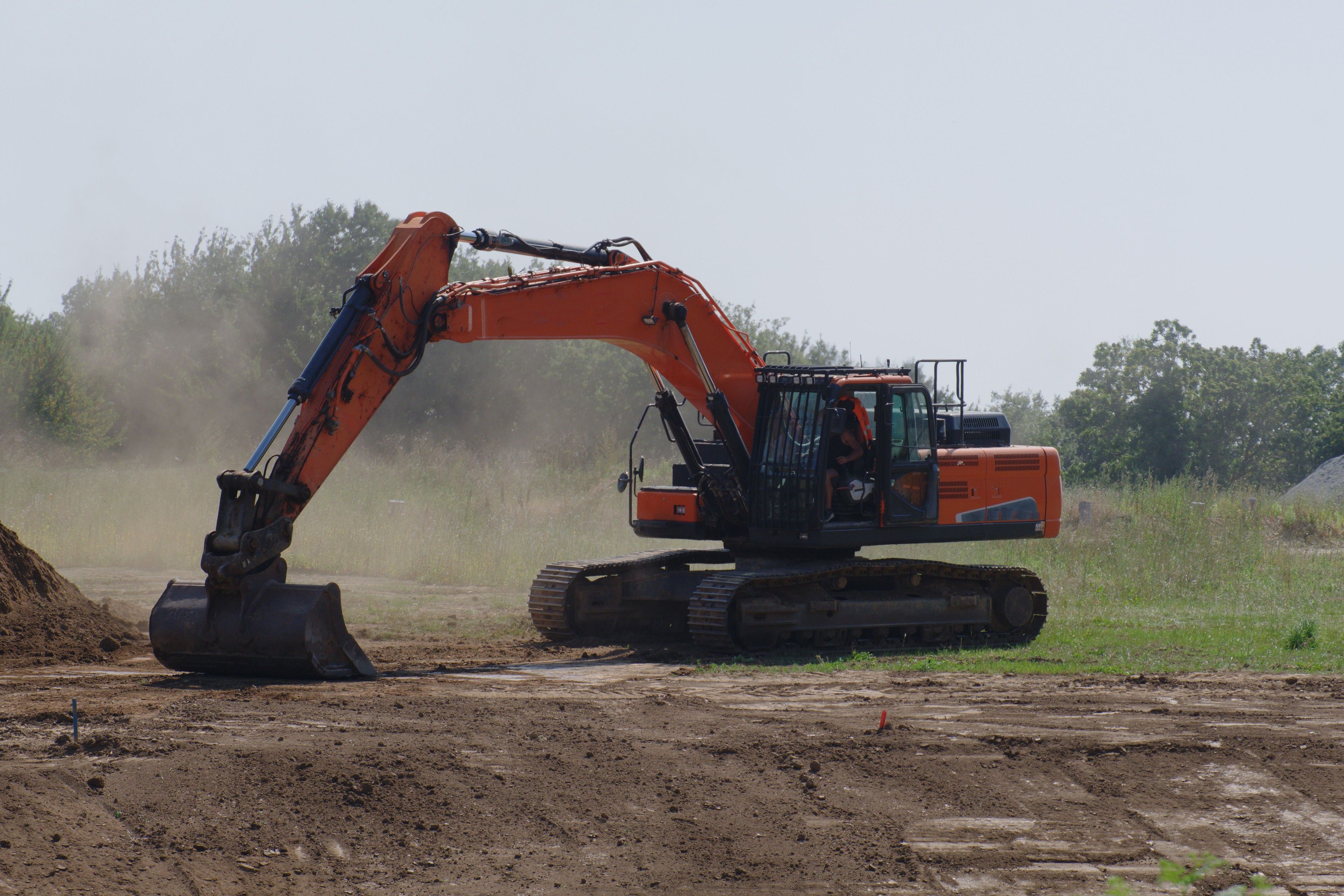 Excavator digging on a dusty job site